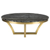 La table de salon AURORA reprend l'élégance d'un style classique avec son plateau rond en marbre noir et ses pieds dorés entrelacés par Maillé Style (Érik Maillé)