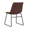 La chaise Carl est une chaise de salle à manger avec une assise en cuir brun et des pieds noirs de style Mid-Century compacte et simple par Maillé Style (Érik Maillé)