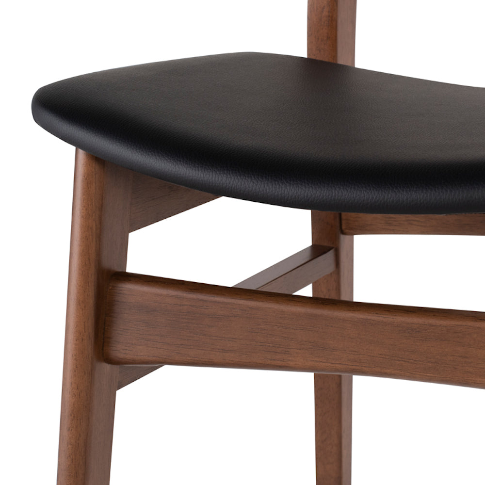La chaise de salle à manger COLBY représente le design scandinave avec ses lignes épurées et ses finis simples de noyer et cuir noir par Maillé Style (Érik Maillé)