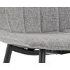 La chaise de salle à manger Drew est compacte et son look décontracté  par le tissu gris clair capitonné en canal et ses pattes de métal noir par Maillé Style (Érik Maillé)