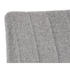 La chaise de salle à manger Drew est compacte et son look décontracté  par le tissu gris clair capitonné en canal et ses pattes de métal noir par Maillé Style (Érik Maillé)
