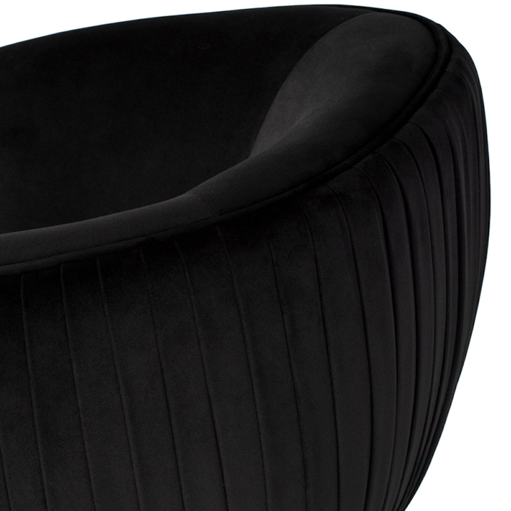 La chaise Sofia est un fauteuil qui présente un profil arrondi recouvert de velours noir plissé, avec des pieds en noir mat par Maillé Style (Érik Maillé)