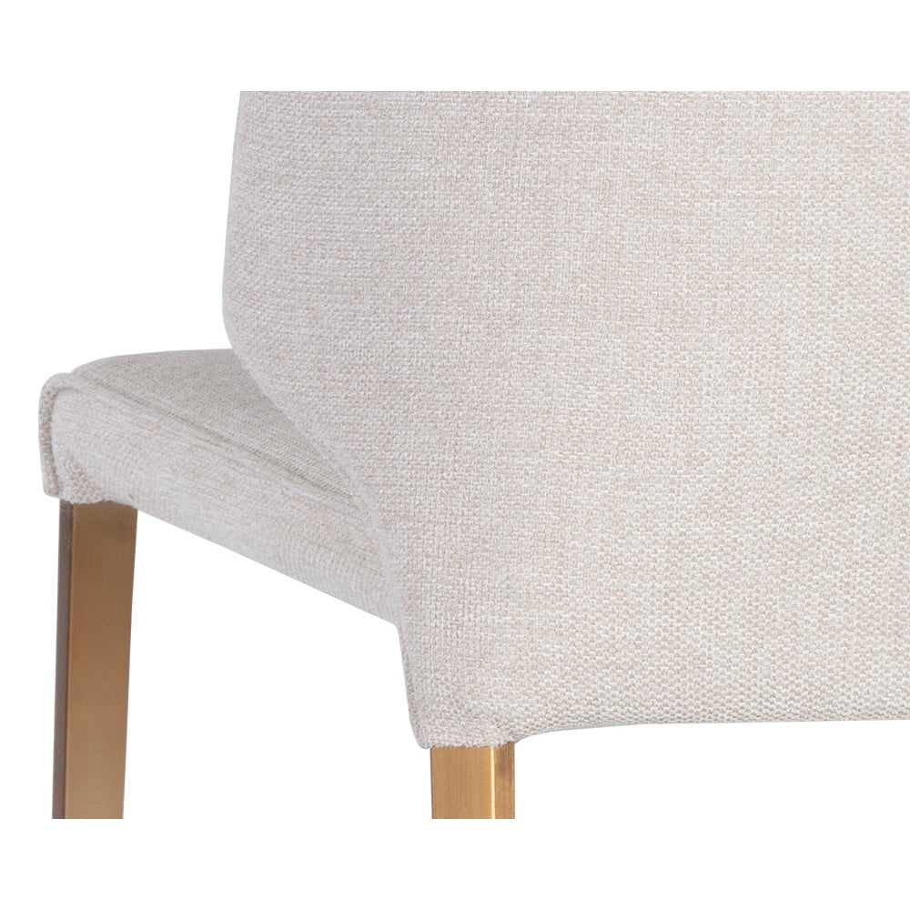 Chaise de salle à manger ZAYDA, chaise élégante et moderne avec son tissu blanc cassé, son capitonnage vertical et ses pieds dorés par Maillé Style (Érik Maillé)
